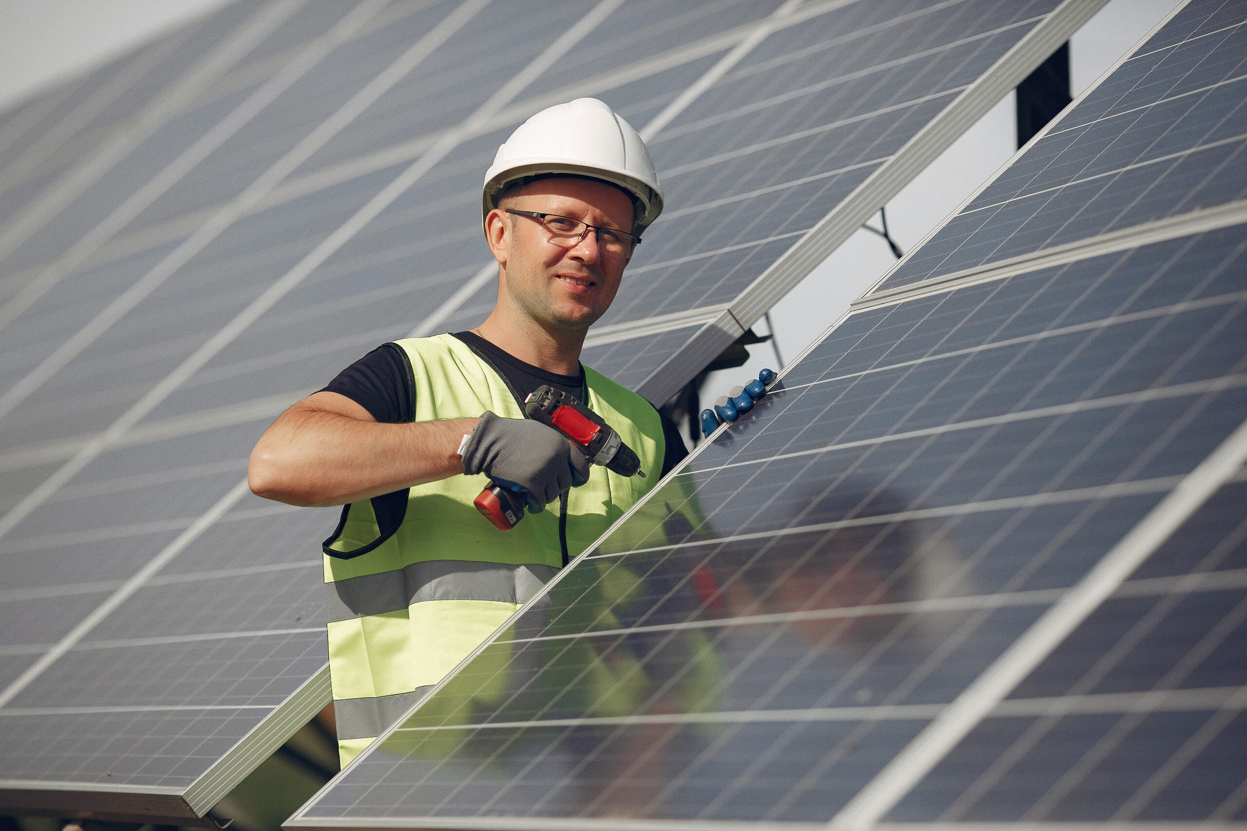man in a white helmet near a solar panel